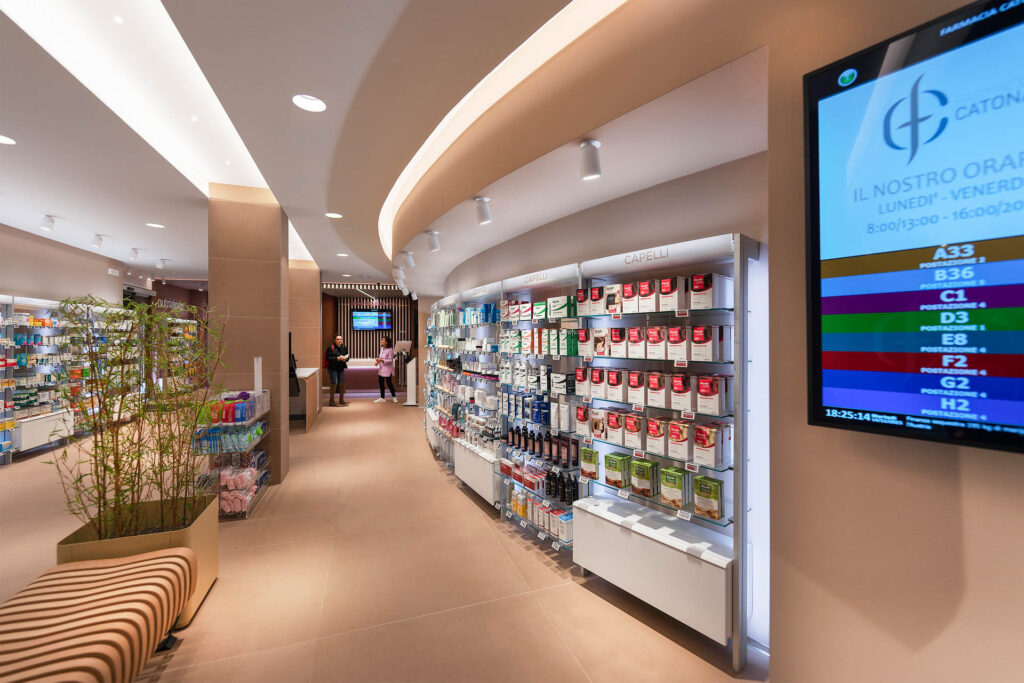 Area dispensazione farmaci della Farmacia San Leo con banchi operativi moderni e illuminazione scenografica.