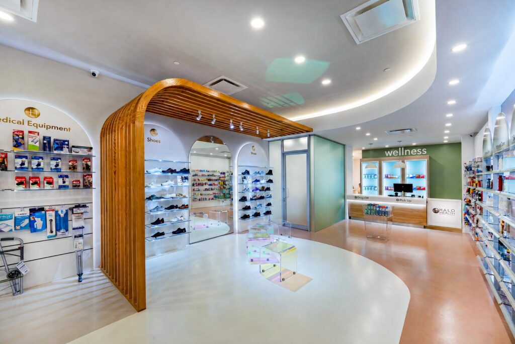 Progettazione farmacia a New York per Halo Health Pharmacy con pareti ad arco, reparti medical equipment e health wellness.