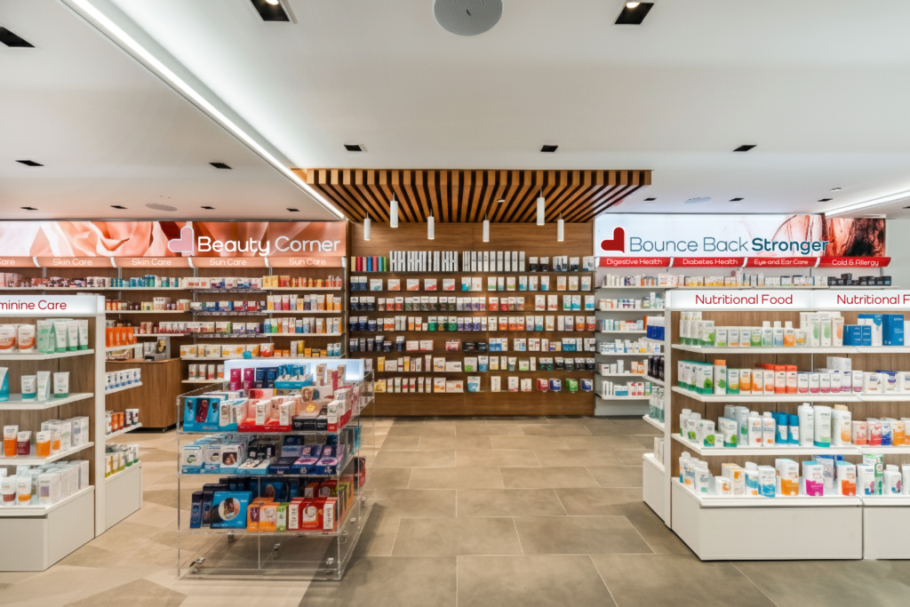 Interno Tribeca Pharmacy con Beauty Corner, area Bounce Back Stronger e scaffali per prodotti wellness.